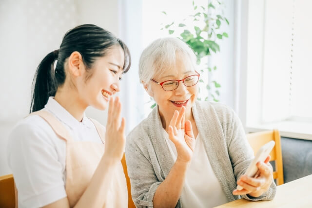 スマホで交流する年配の母娘