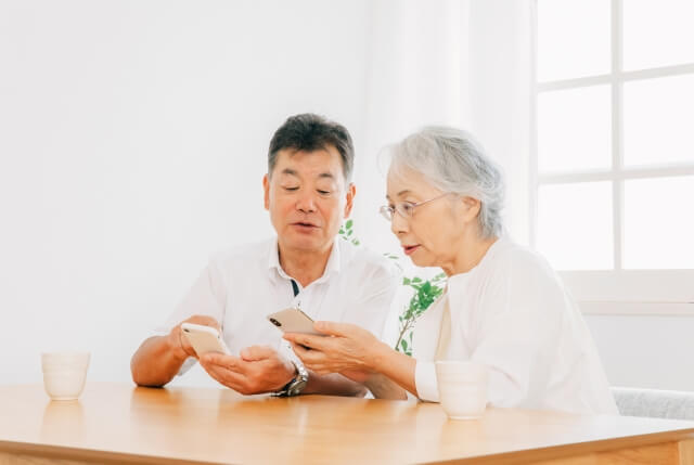 スマートフォンを見る年配のカップル