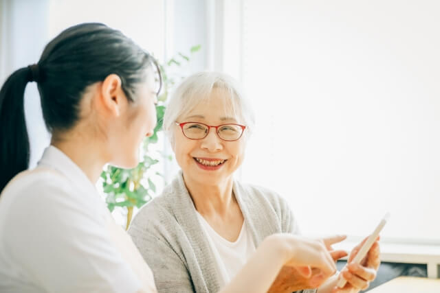 タブレットを使うシニア女性と介護士