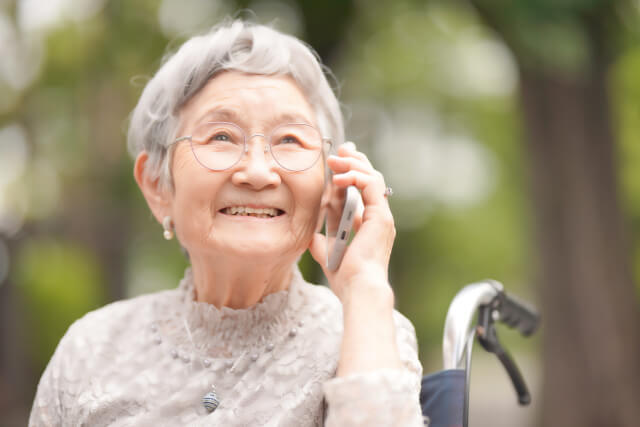 電話で話す笑顔の年配の女性
