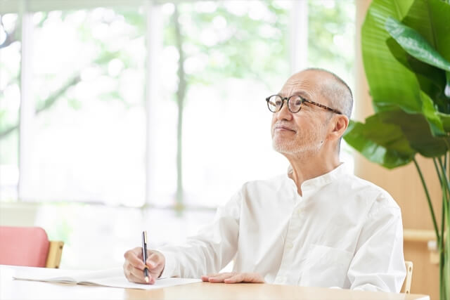 明るい室内で笑顔の白髪の男性
